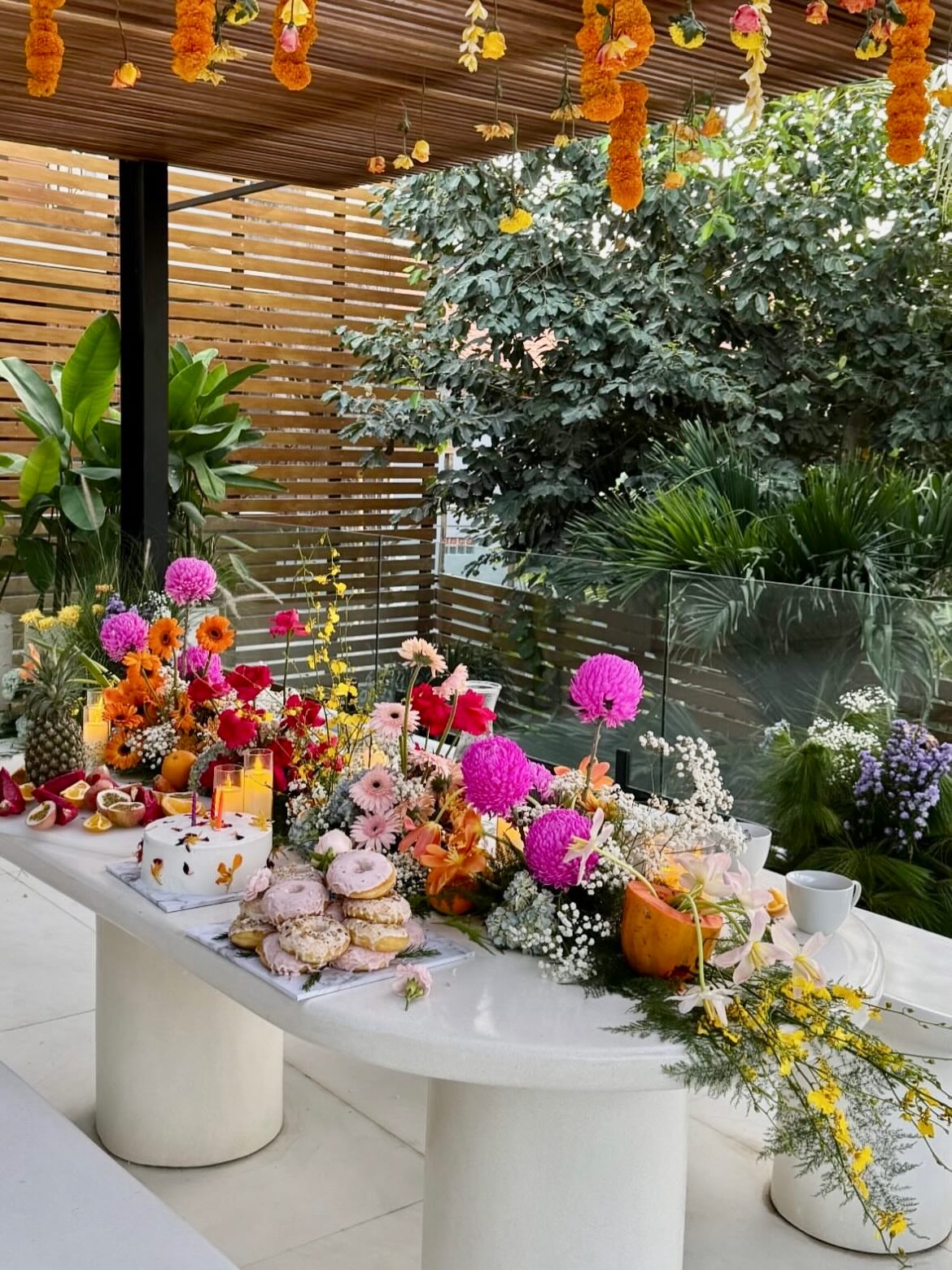 Colorful floral tablescape with fruit, flowers, and dessert styling